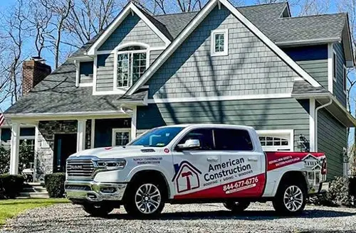 An American Construction truck in front of a house with new siding